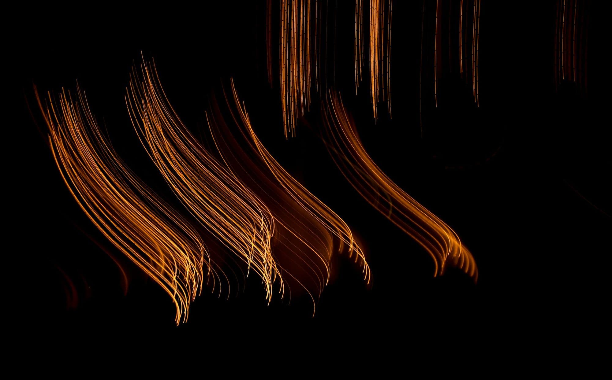 Orange long-exposure light streaks on black